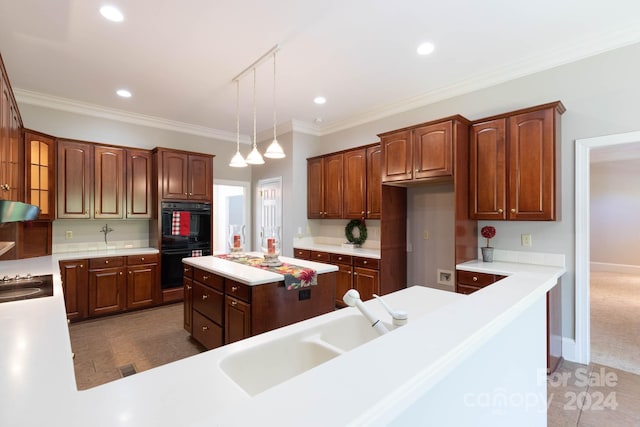 kitchen featuring carpet flooring, double oven, crown molding, sink, and pendant lighting