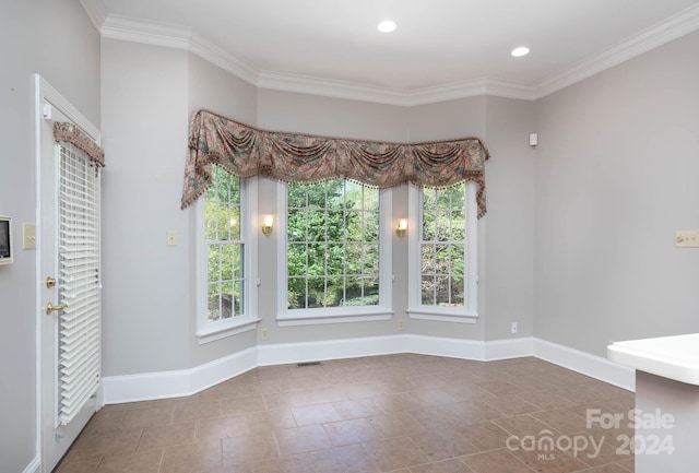 unfurnished dining area with tile patterned floors, a healthy amount of sunlight, and ornamental molding