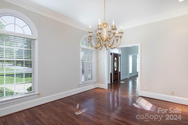 unfurnished dining area with dark hardwood / wood-style flooring, an inviting chandelier, and crown molding