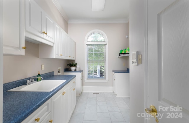 kitchen featuring white cabinetry, sink, and ornamental molding