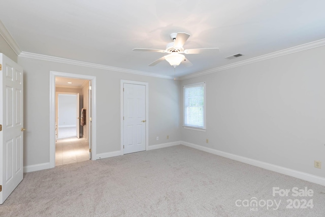 carpeted empty room with ceiling fan and crown molding