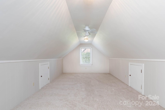 additional living space with light carpet, ceiling fan, and vaulted ceiling