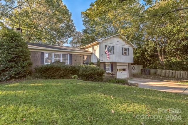 split level home featuring a front lawn and a garage