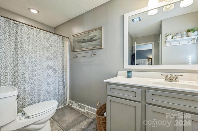 bathroom featuring toilet, a textured ceiling, walk in shower, and vanity