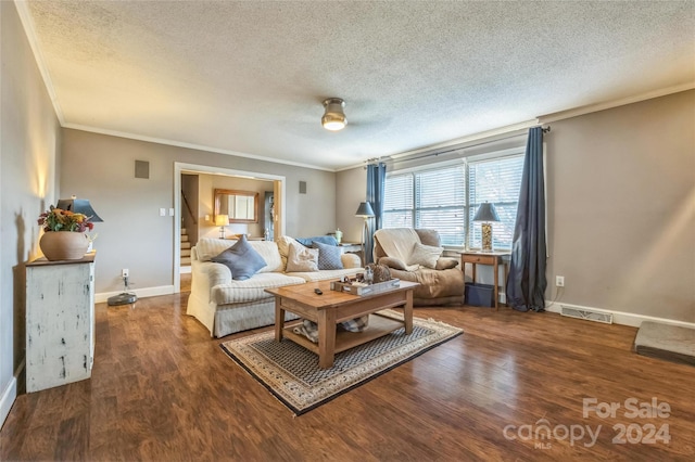 living room featuring ornamental molding, dark wood-type flooring, and a textured ceiling