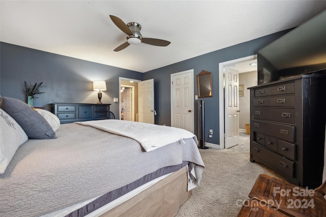 carpeted bedroom featuring ensuite bathroom and ceiling fan