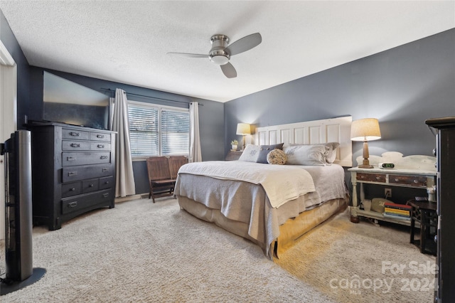 bedroom featuring ceiling fan, carpet flooring, and a textured ceiling