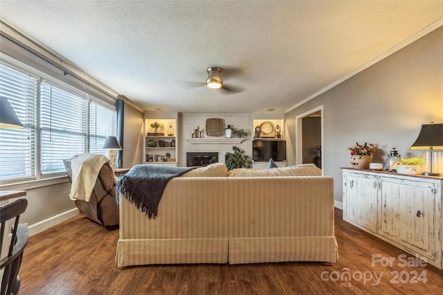 living room with hardwood / wood-style flooring, crown molding, a textured ceiling, a fireplace, and ceiling fan