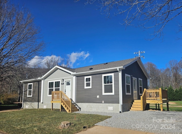 view of front of home featuring a front yard and a wooden deck