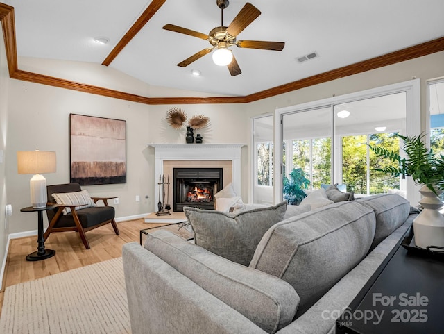 living room featuring crown molding, ceiling fan, light hardwood / wood-style flooring, and vaulted ceiling with beams