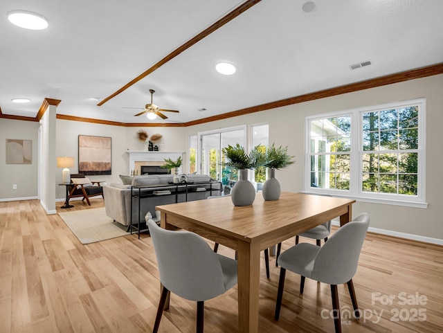 dining area with ceiling fan, ornamental molding, and light hardwood / wood-style floors