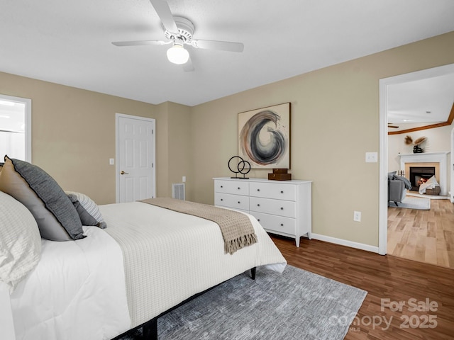 bedroom with dark hardwood / wood-style flooring and ceiling fan