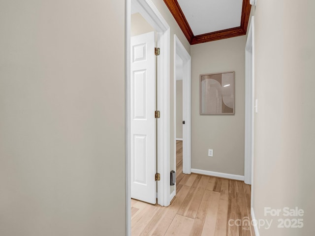 hallway featuring ornamental molding and light wood-type flooring