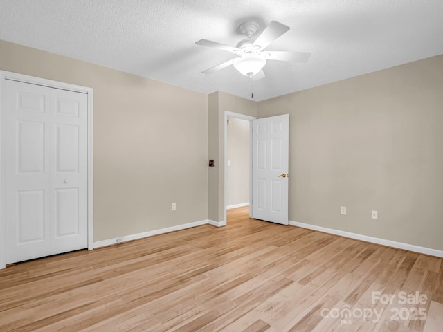 unfurnished bedroom with ceiling fan, light hardwood / wood-style flooring, and a textured ceiling