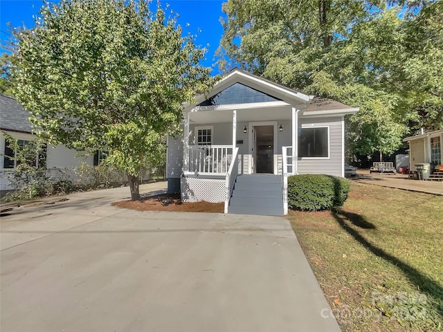 bungalow with a front yard and covered porch