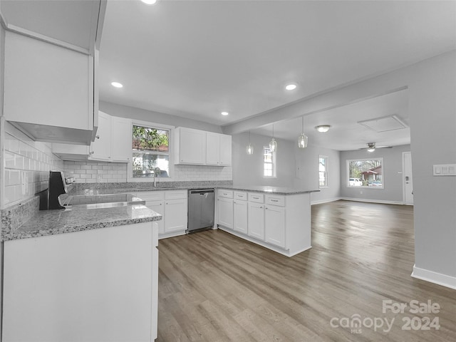 kitchen featuring backsplash, kitchen peninsula, white cabinetry, stainless steel appliances, and light hardwood / wood-style flooring