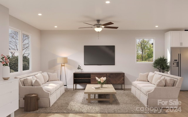 living room with light hardwood / wood-style flooring and ceiling fan