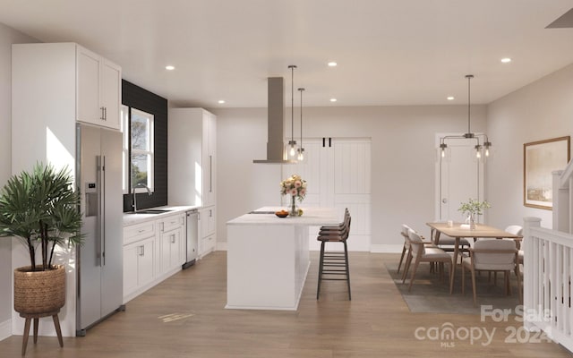 kitchen with ventilation hood, decorative light fixtures, white cabinetry, and hardwood / wood-style floors