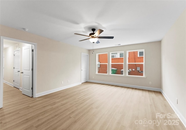 unfurnished room with light wood finished floors, a ceiling fan, and baseboards