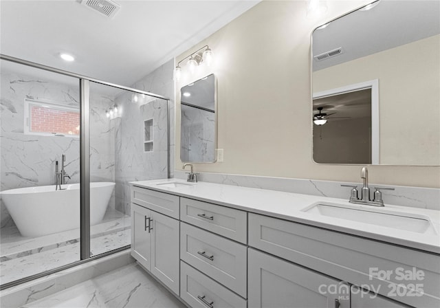 full bathroom featuring a soaking tub, a sink, and visible vents