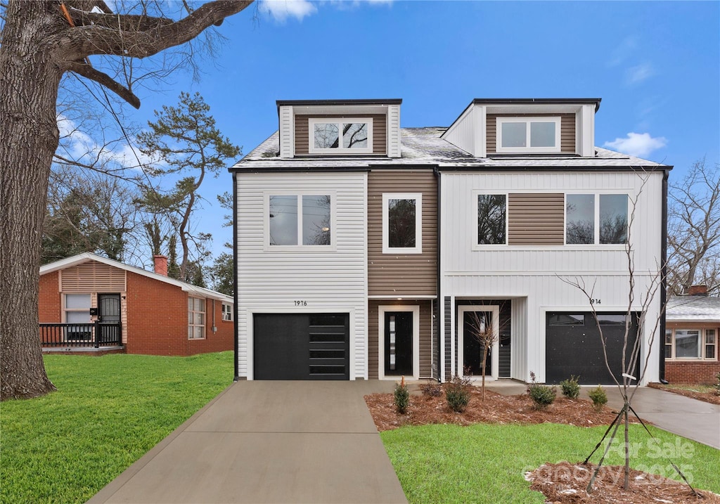 view of front of home with a garage, driveway, and a front lawn