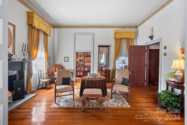 sitting room featuring wood-type flooring and ornamental molding