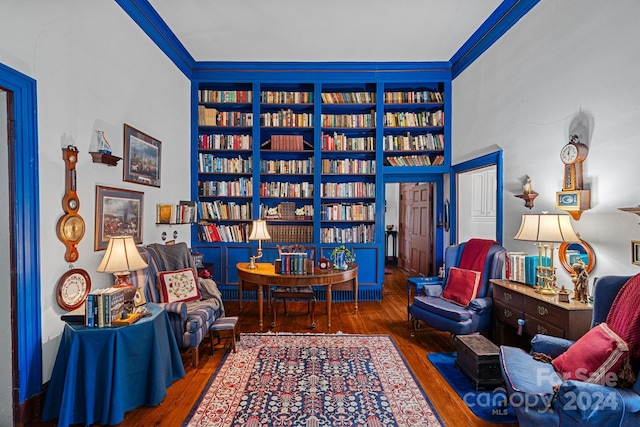 living area featuring crown molding and dark wood-type flooring