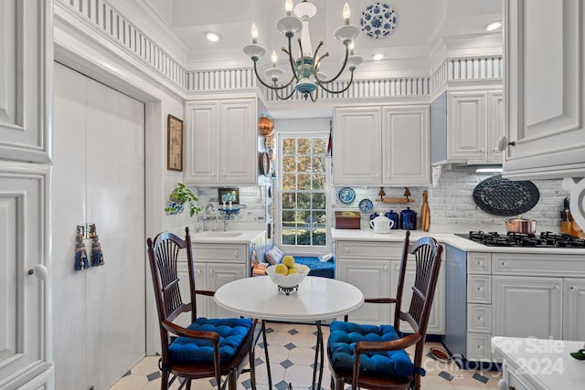 kitchen with white cabinets, a notable chandelier, and gas cooktop