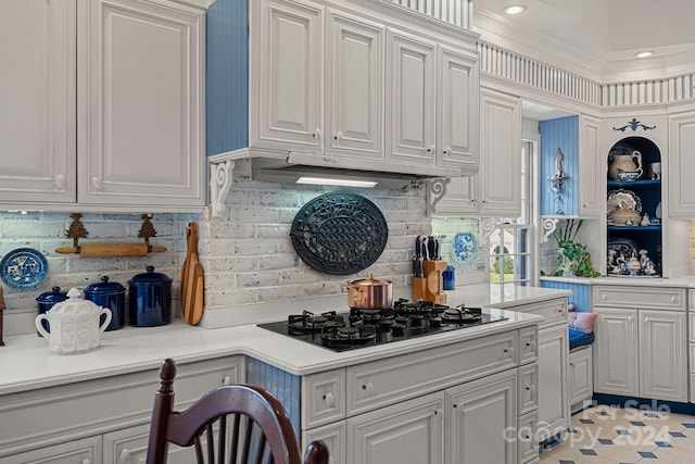 kitchen with decorative backsplash, black gas stovetop, crown molding, light tile patterned floors, and white cabinets