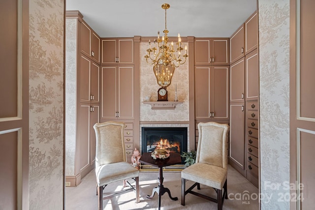 sitting room featuring a chandelier, light carpet, and a large fireplace