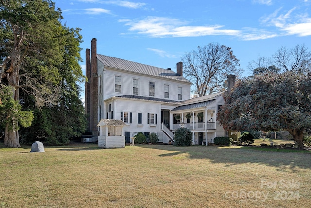 rear view of property featuring a lawn