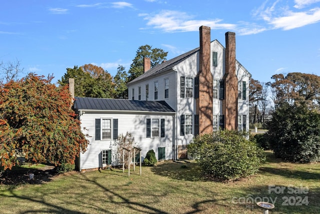 rear view of property featuring a lawn