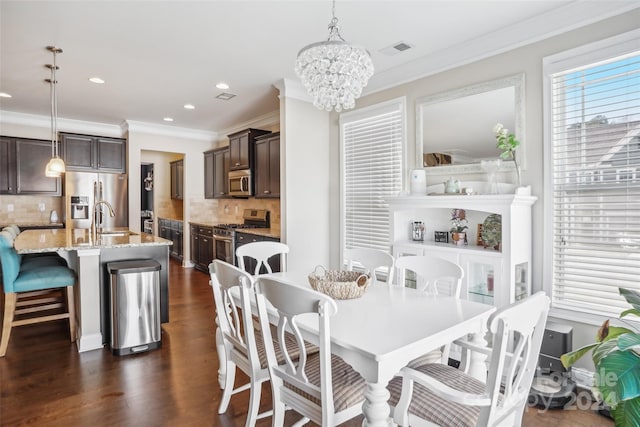 dining space with sink, dark hardwood / wood-style floors, and ornamental molding