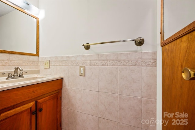 bathroom with tile walls, wainscoting, and vanity