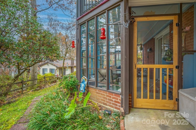 view of side of home featuring brick siding and fence