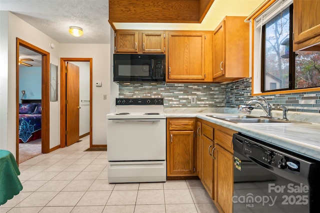 kitchen featuring tasteful backsplash, light countertops, a sink, a textured ceiling, and black appliances