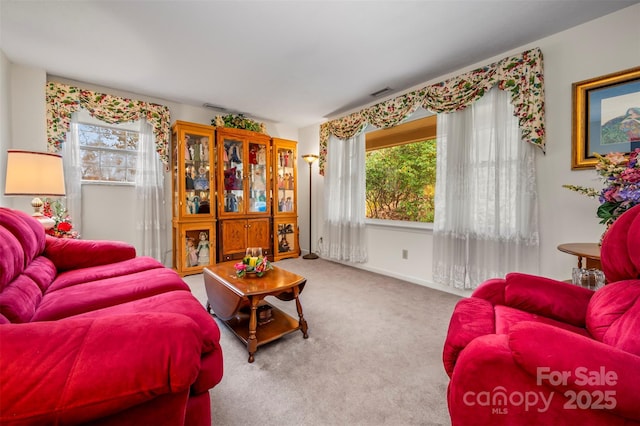 living room featuring carpet, visible vents, and baseboards