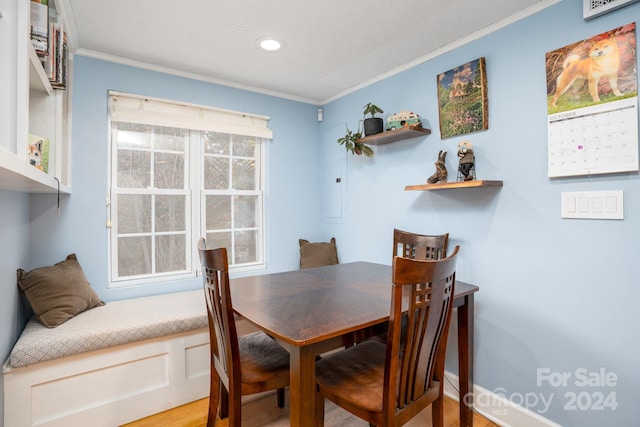 dining space featuring ornamental molding and hardwood / wood-style flooring