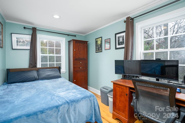 bedroom with crown molding, multiple windows, and light hardwood / wood-style floors