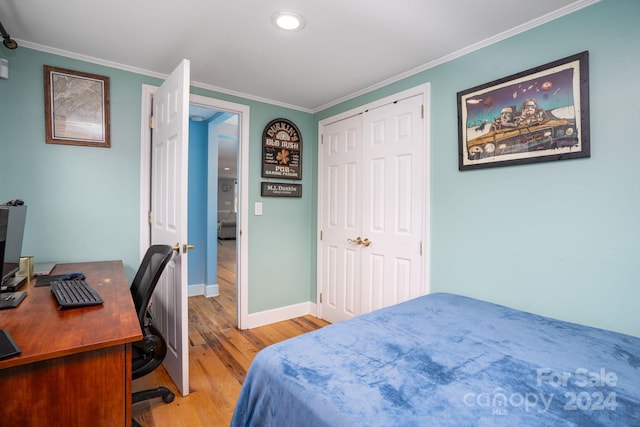 bedroom with a closet, crown molding, and light hardwood / wood-style floors