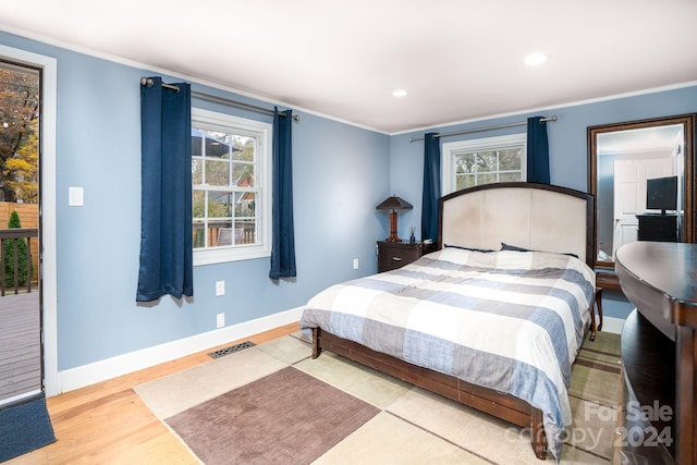 bedroom with ornamental molding and hardwood / wood-style floors