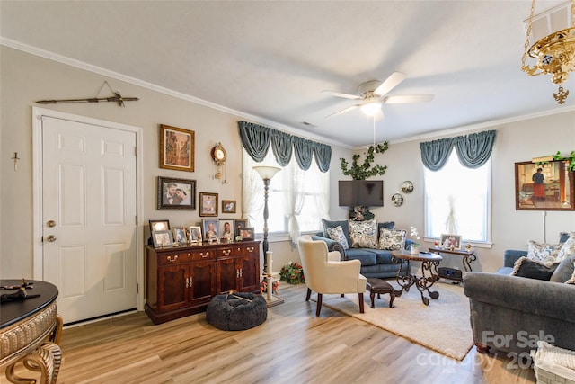 living room with ornamental molding, light hardwood / wood-style flooring, and a healthy amount of sunlight