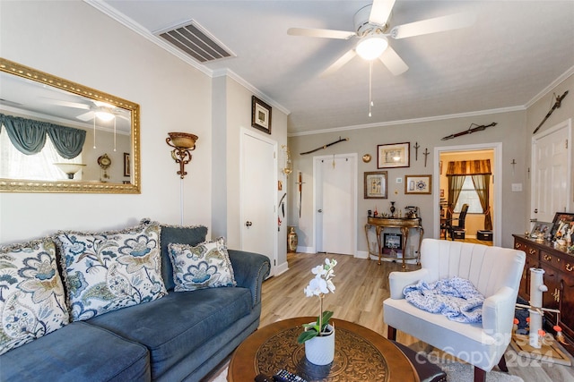 living room featuring light hardwood / wood-style floors, crown molding, and ceiling fan