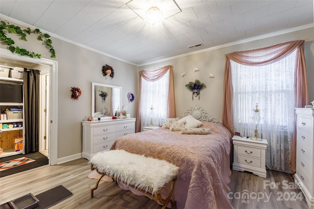 bedroom featuring ornamental molding and light wood-type flooring