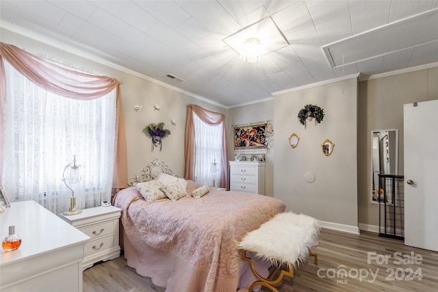 bedroom featuring crown molding and light hardwood / wood-style floors