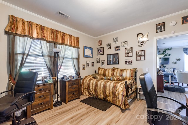 bedroom with light hardwood / wood-style flooring and crown molding