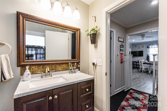 bathroom featuring vanity, hardwood / wood-style floors, ceiling fan, and tasteful backsplash