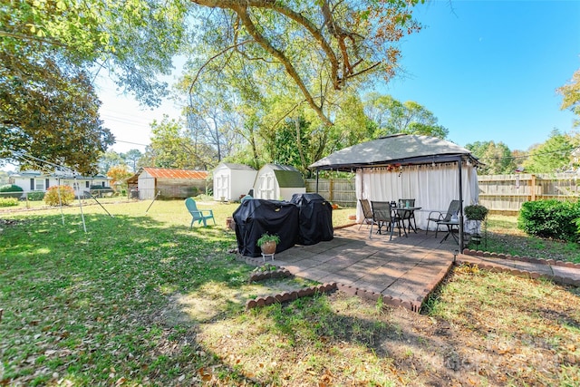 view of yard featuring a shed, a patio area, and a gazebo