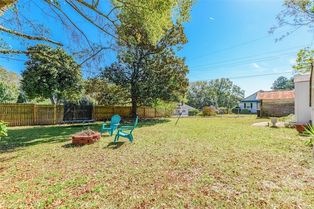 view of yard featuring an outdoor fire pit and a trampoline