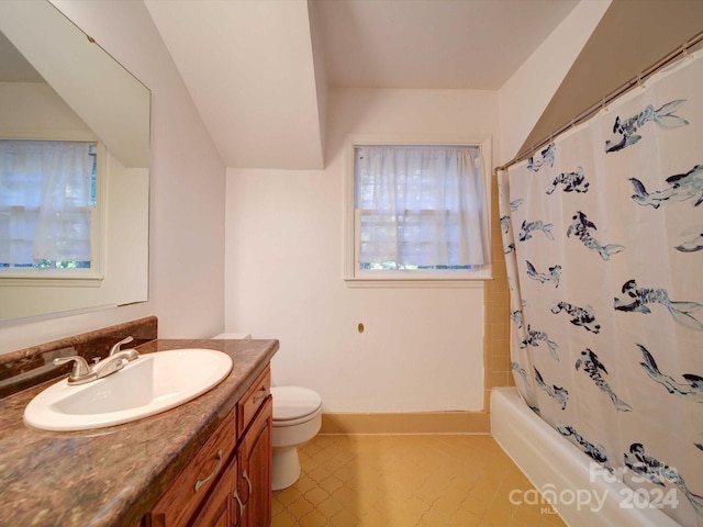 full bathroom featuring toilet, vanity, tile patterned floors, and shower / bath combo with shower curtain